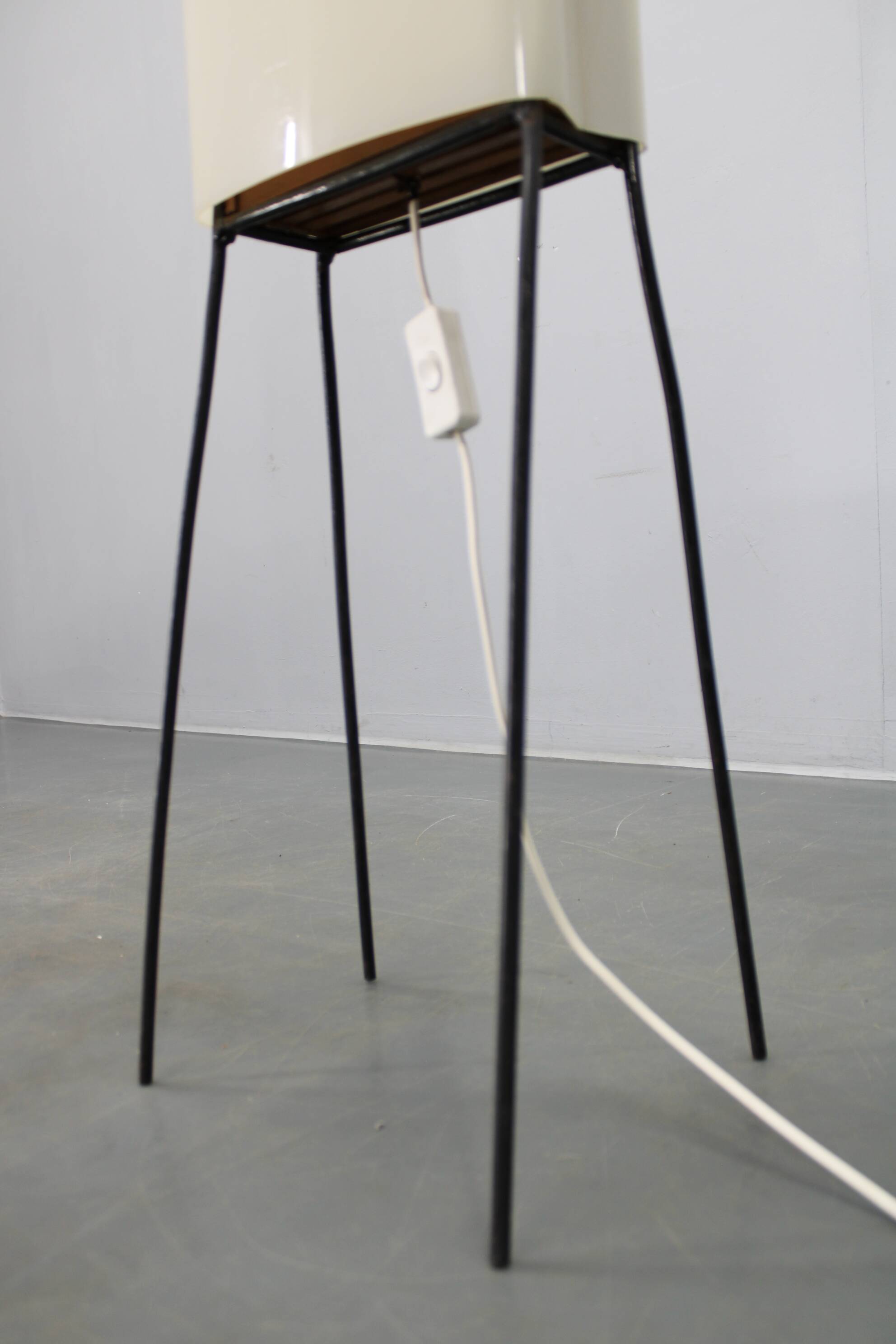 Mid-century modern floor lamp on iron legs with plastic shade and wood accent