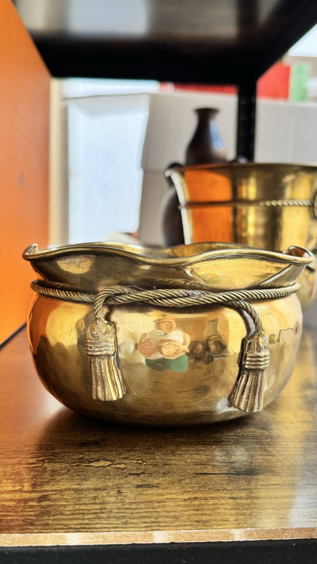 Pair of brass plant pots, decorated with cord and tassels.