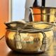 Pair of brass plant pots, decorated with cord and tassels.