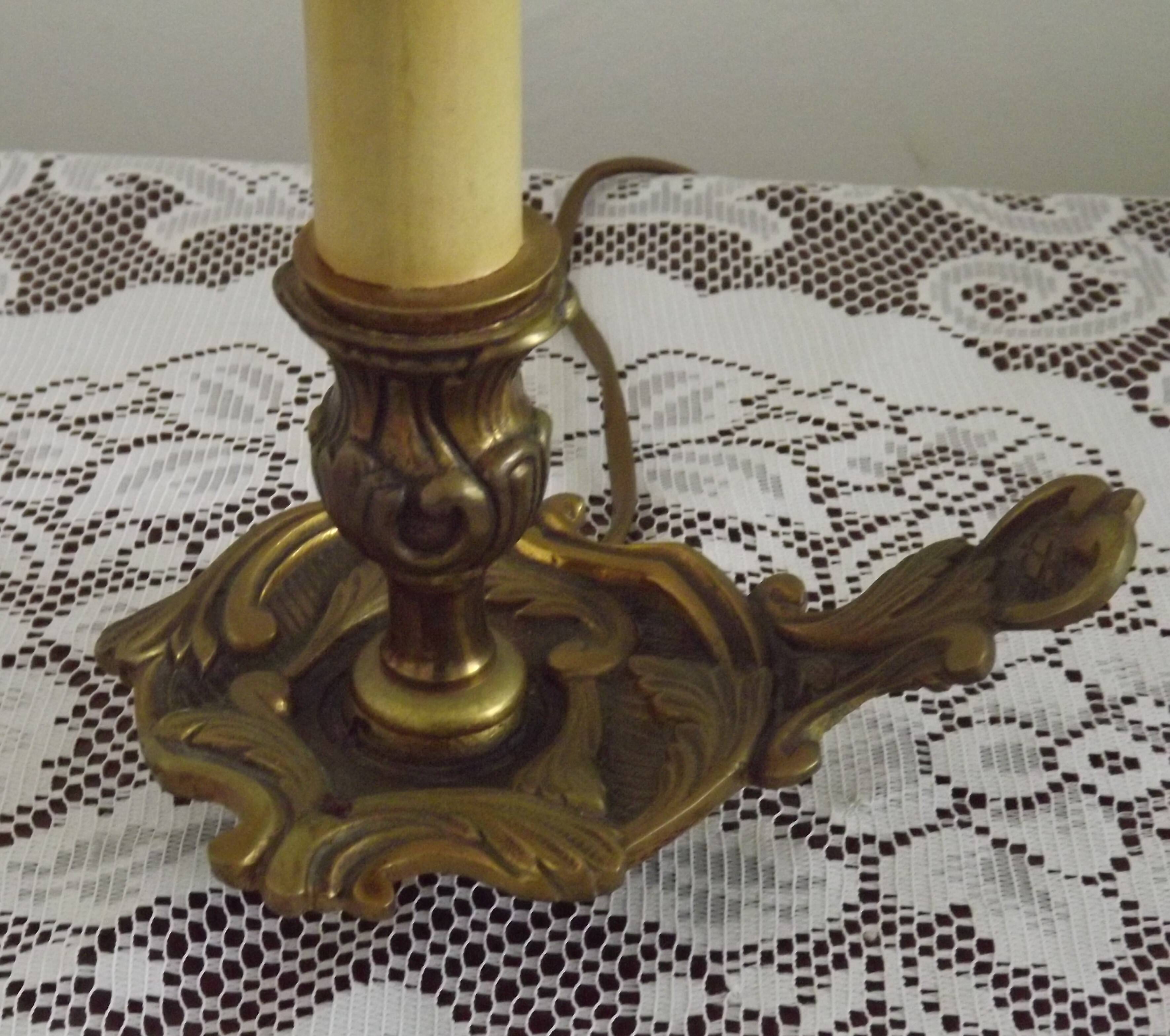 Vintage French bronze Wee Willie Winkie style lamp with red card shade.