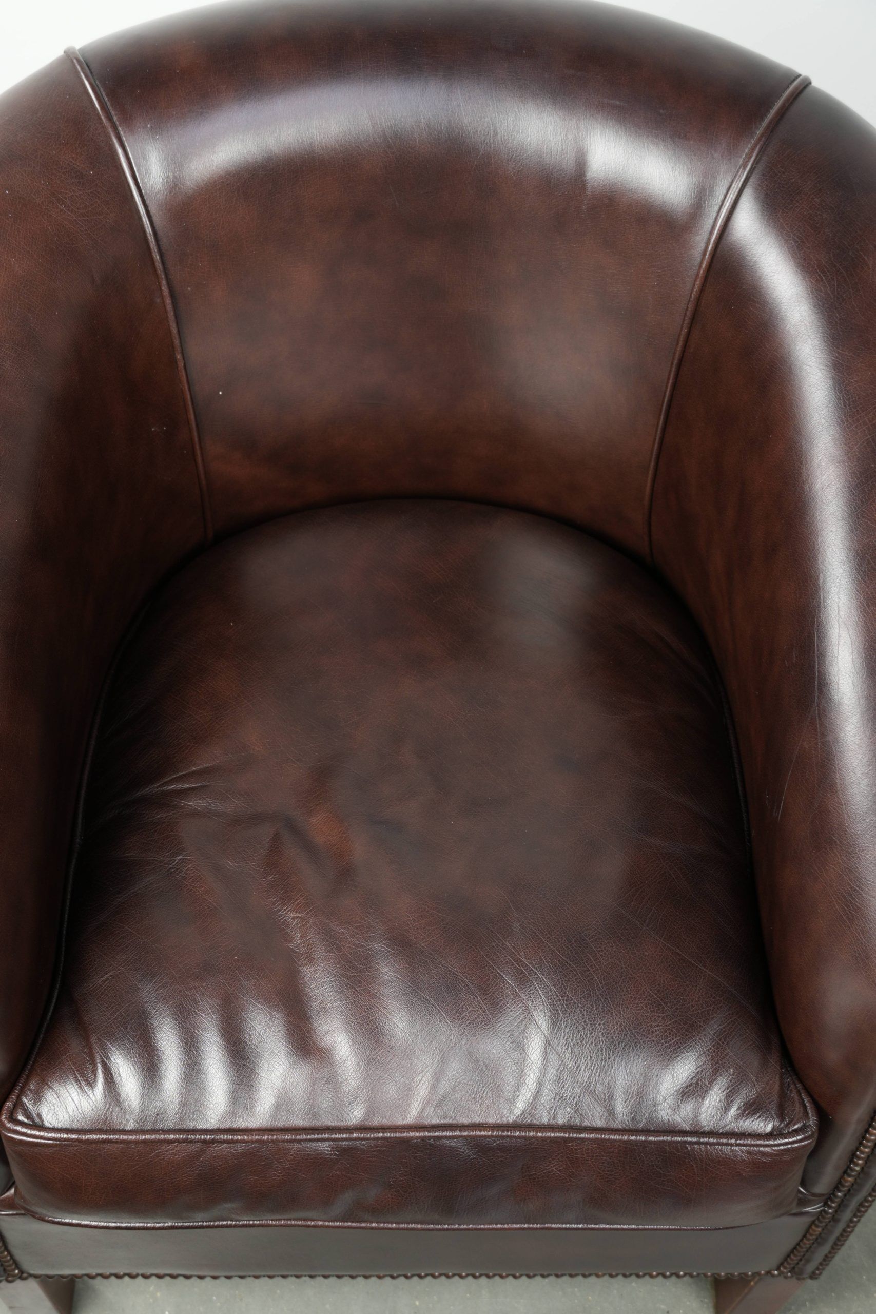 Dark cow leather club armchair in good condition with an English design