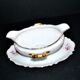Vintage pouring sauce boat in floral porcelain with gilding.