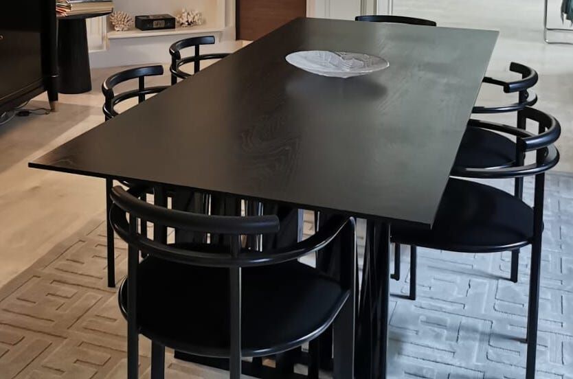 Black dining room table, wooden, rectangle with upholstered chairs.