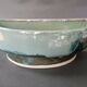 Glazed stoneware jardinière in almond green, semi-circular, signed.