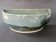 Glazed stoneware jardinière in almond green, semi-circular, signed.