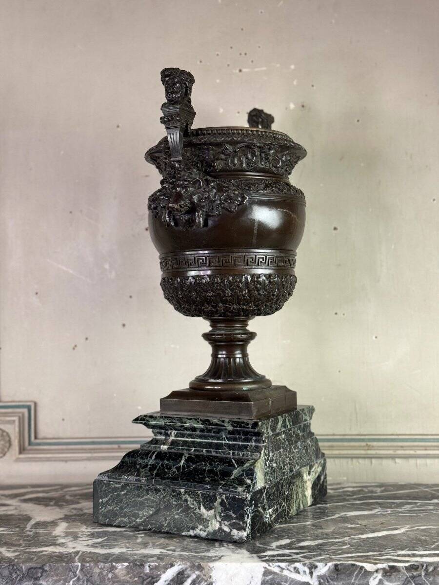 Patinated bronze vase with handles topped by bicéphalic busts, 19th century.