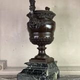 Patinated bronze vase with handles topped by bicéphalic busts, 19th century.