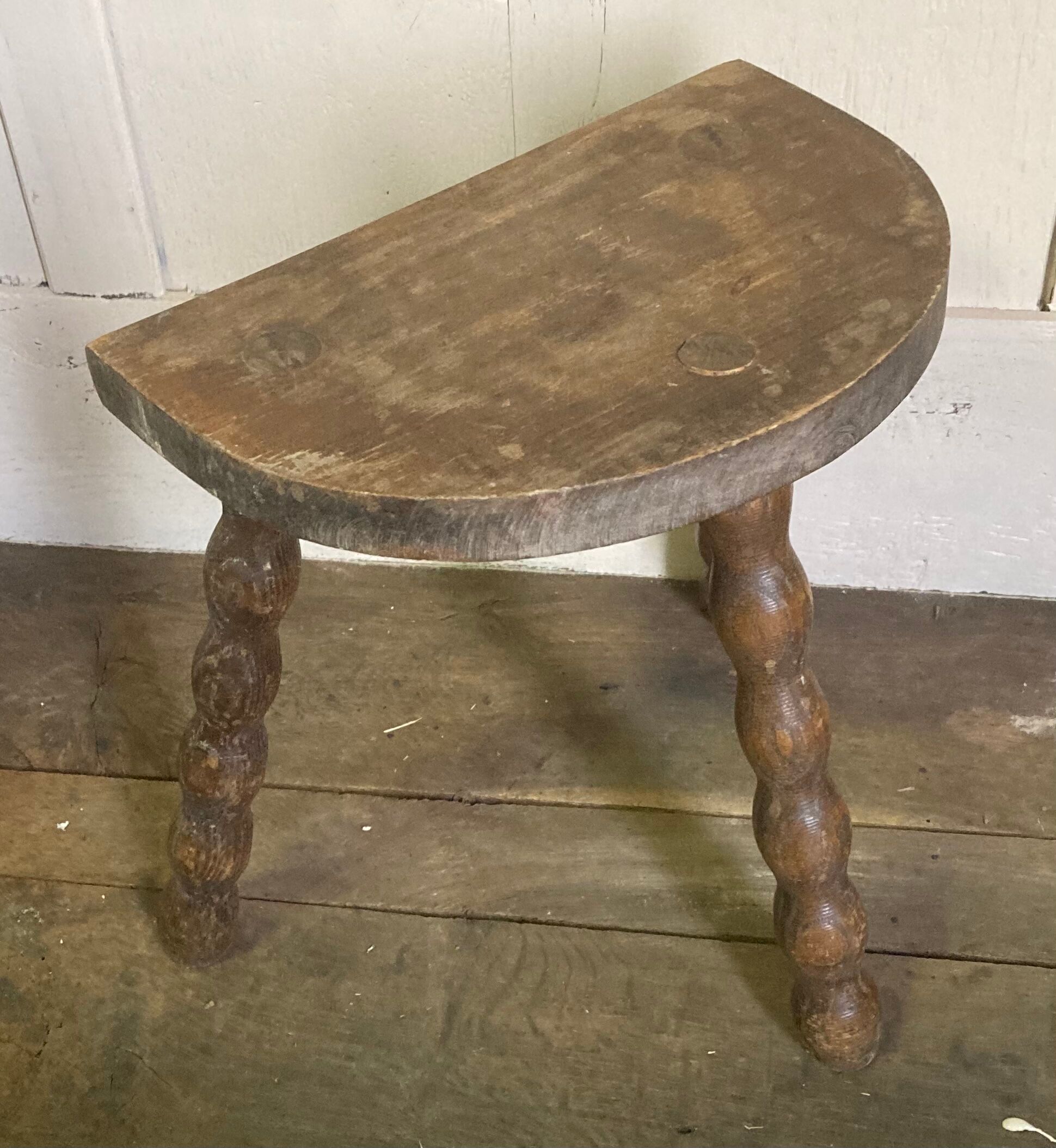 Half-moon tripod stool.