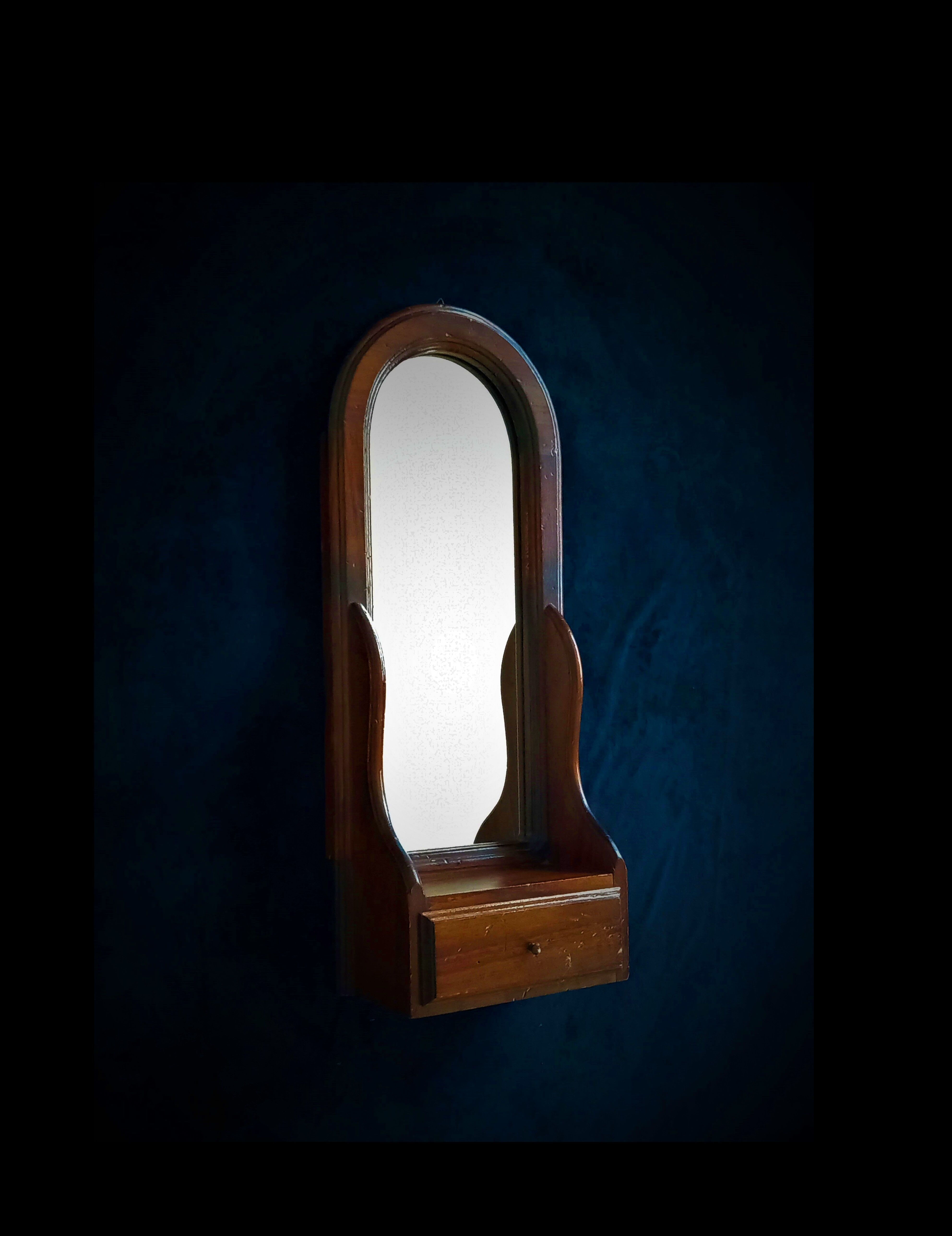 Wall mirror in arched frame with drawer