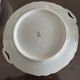 This dish appears to be a serving dish or a round plate with handles made of porcelain.