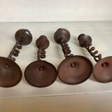 Four twisted metal candle holders with a rusty appearance
