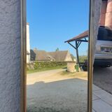 Mirror between two in gilded wood