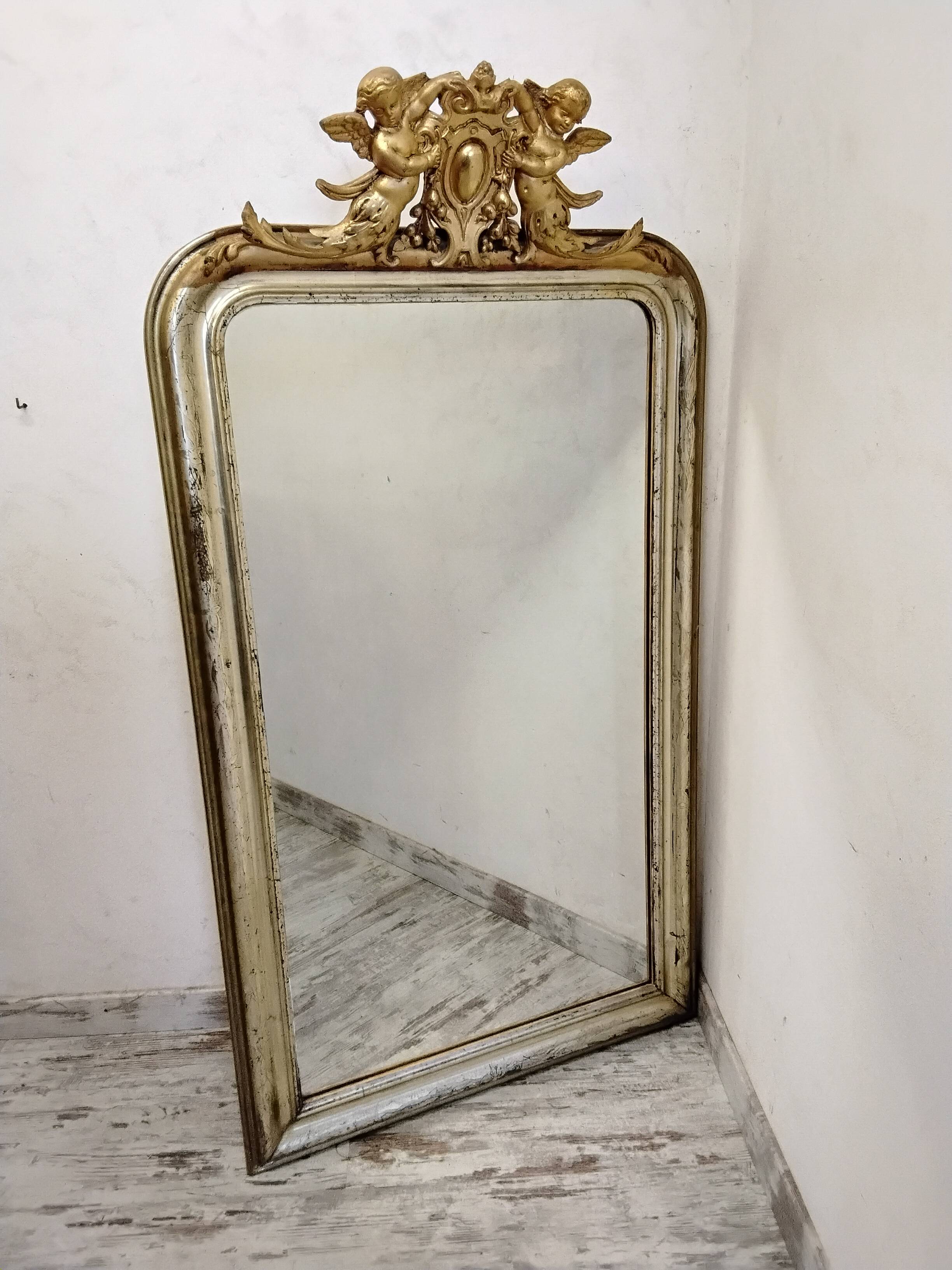 Antique mirror with a gilded frame and cherubs.