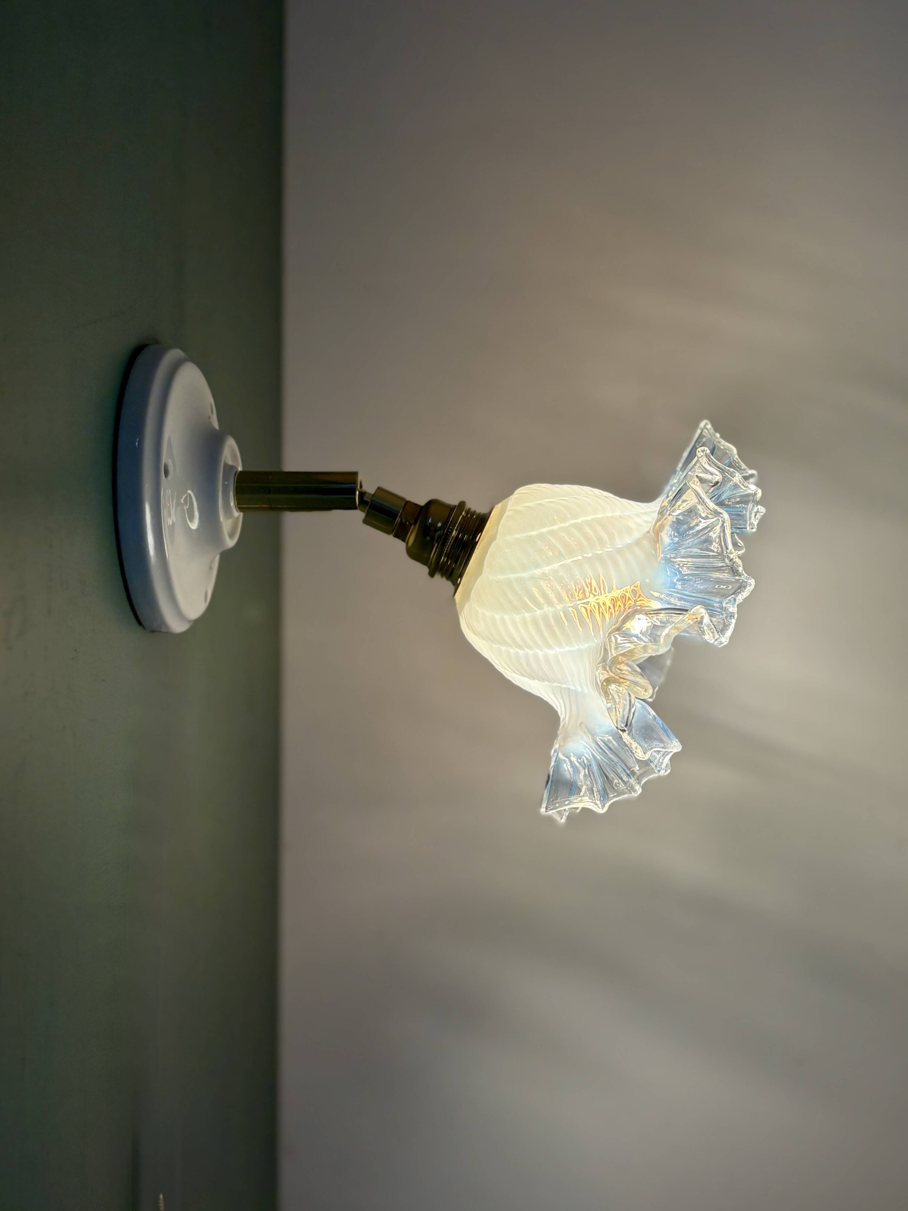 Vintage tulip glass wall light in transparent, slightly pearlescent white.