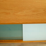 A pair of vintage mid-century bedside tables with glass sliding doors