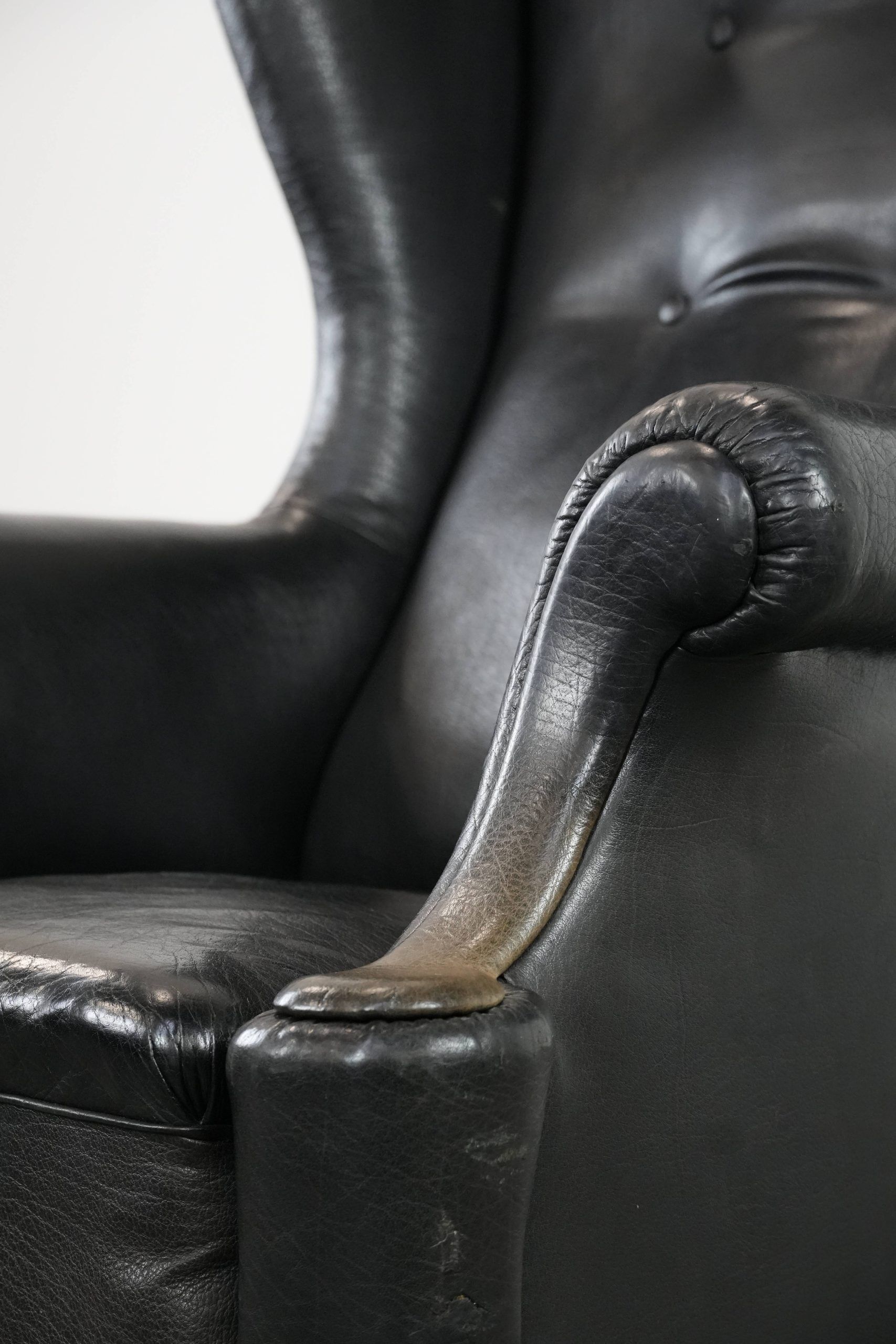 Antique black English cow leather wingback armchair from the 19th century