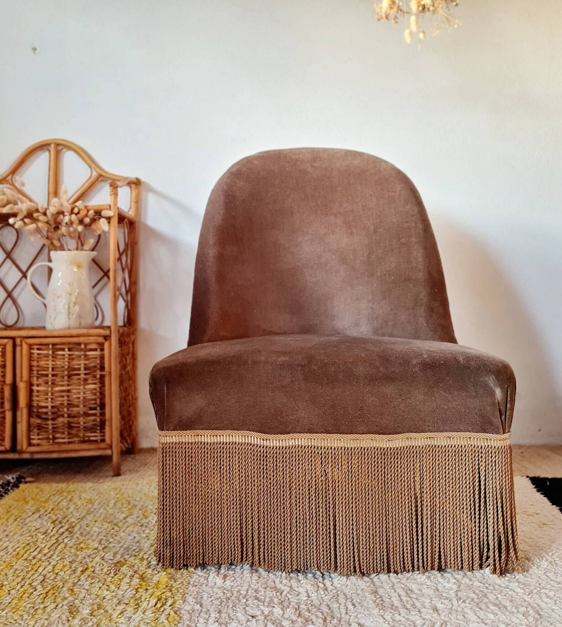 Brown velvet crapaud armchair with fringes and sculpted legs.