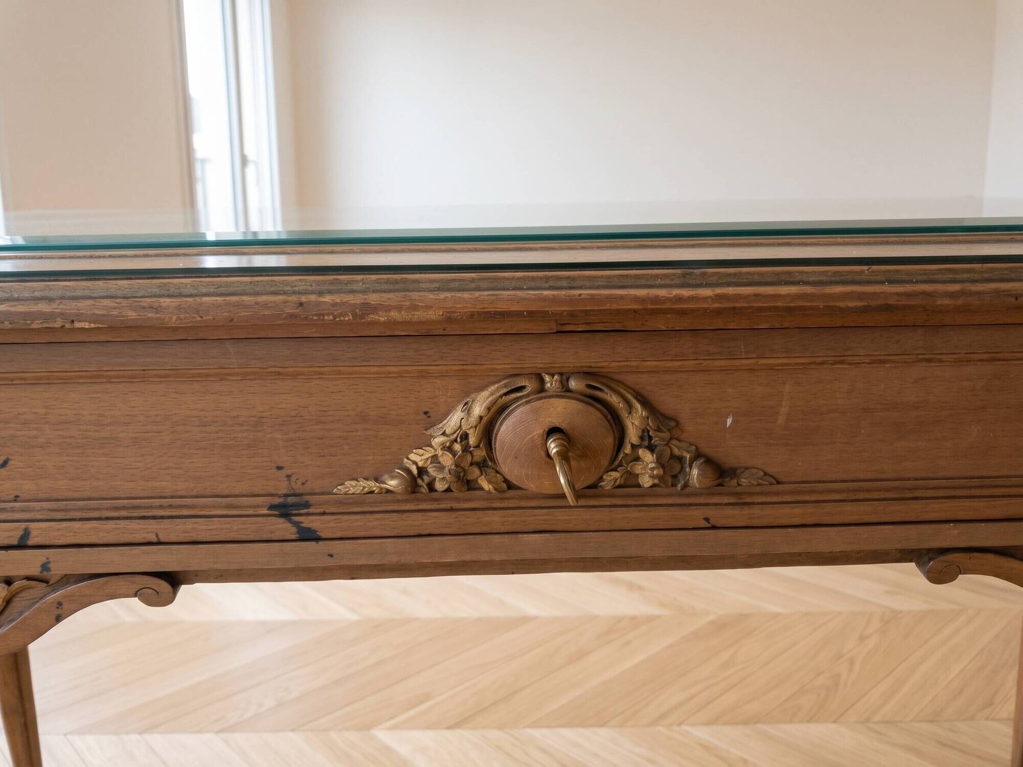 Solid wood desk with glass top and sculptures.