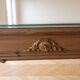 Solid wood desk with glass top and sculptures.