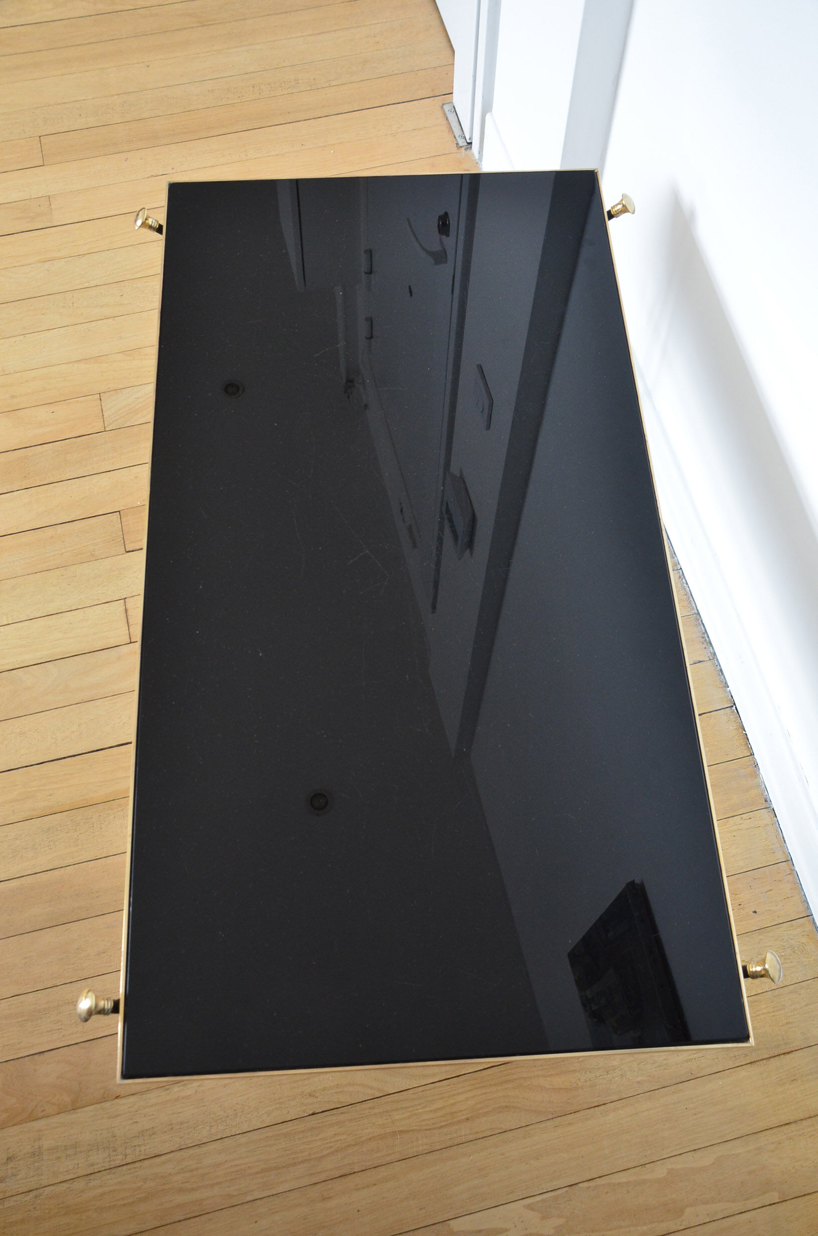 Black glass and brass coffee table in the 1960s