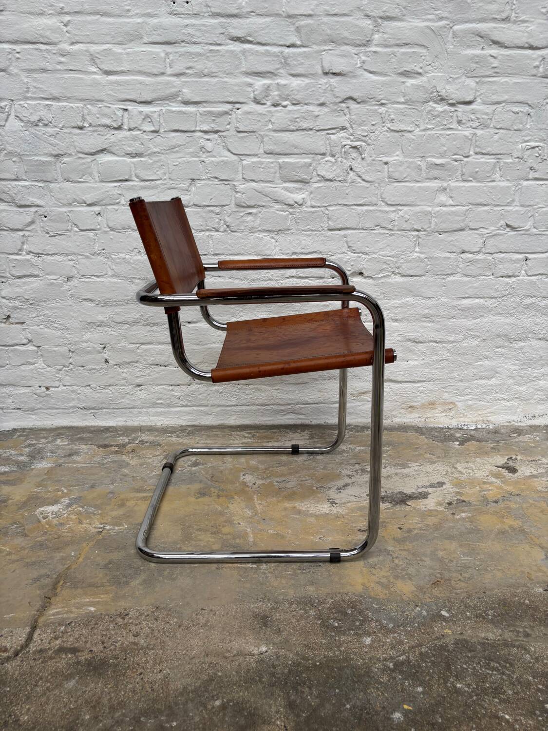 Vintage aluminum tube and tan leather armchair