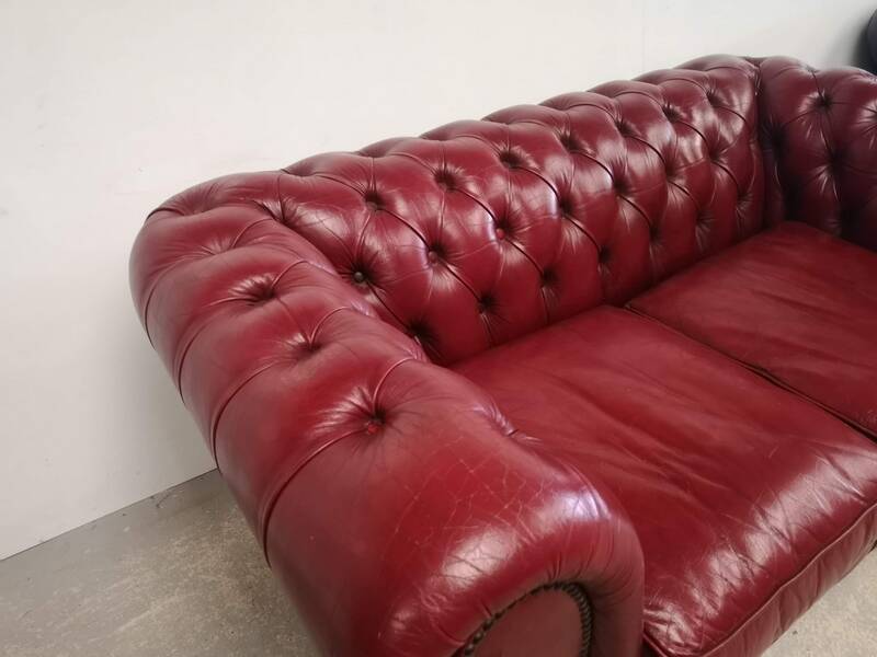 Red two-seater chesterfield sofa