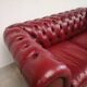 Red two-seater chesterfield sofa