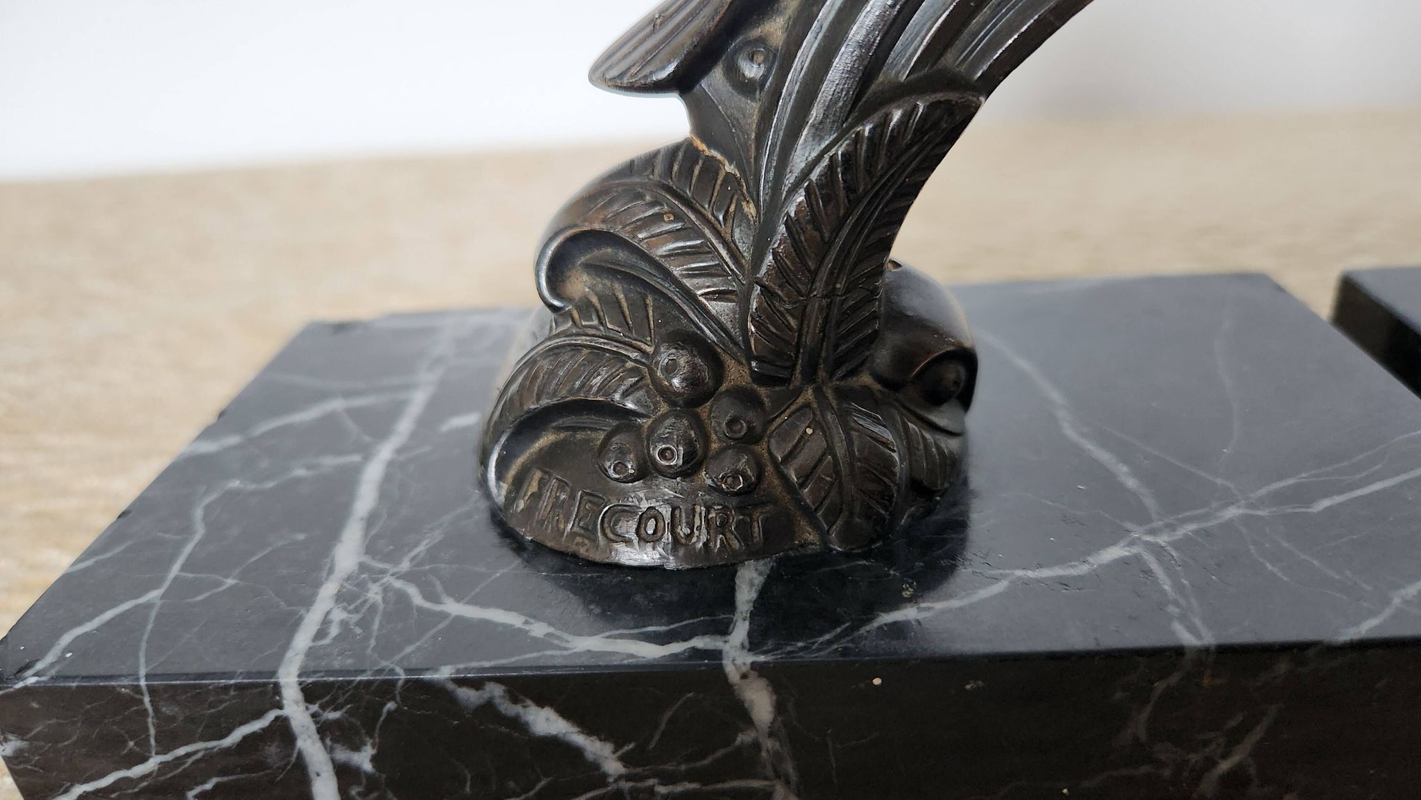 Pair of Art Deco bookends signed Frécourt, patinated metal & black marble
