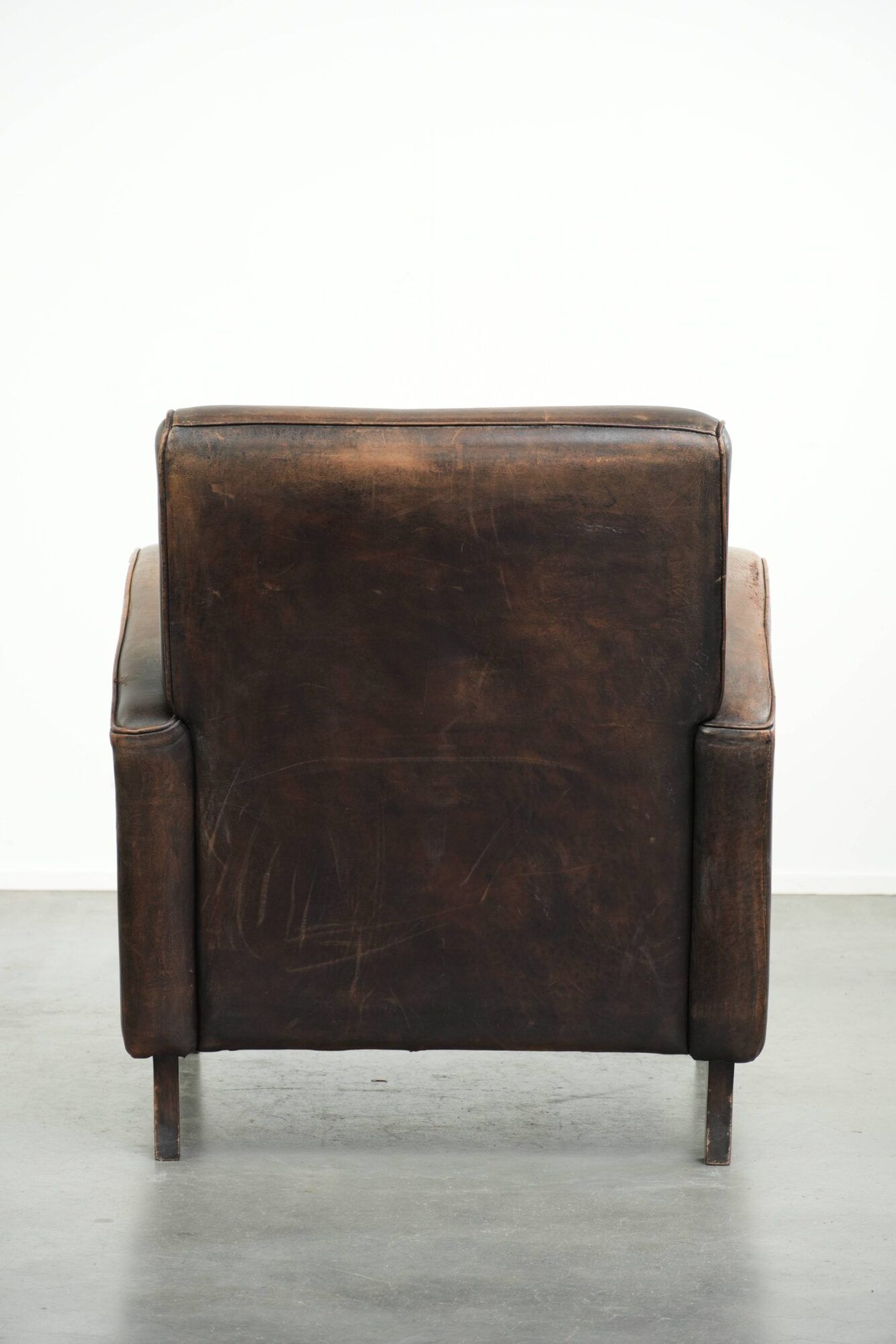Comfortable sheepskin armchair with matching piping and a timeless look