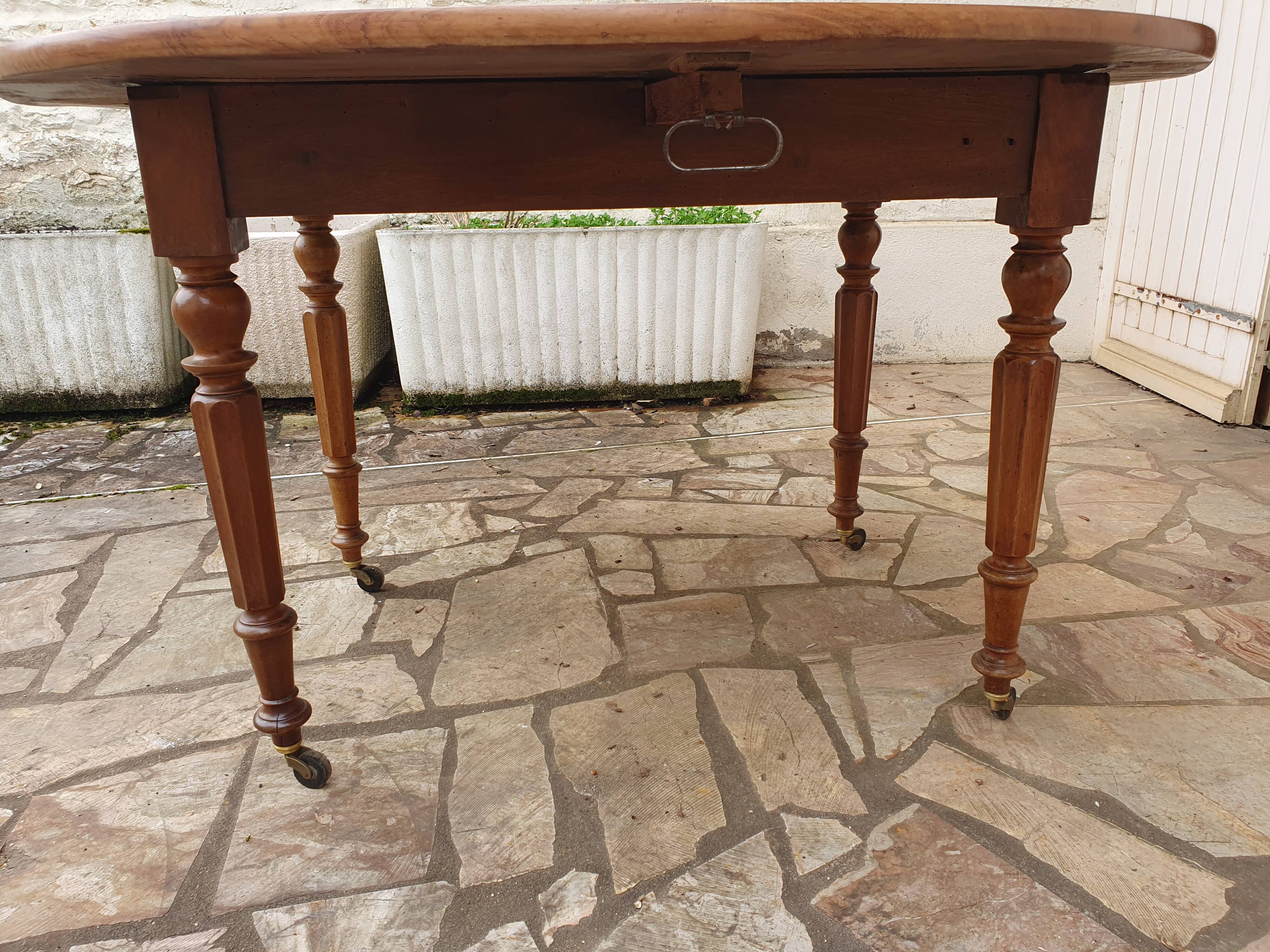 Round extending table in solid walnut, 19th century