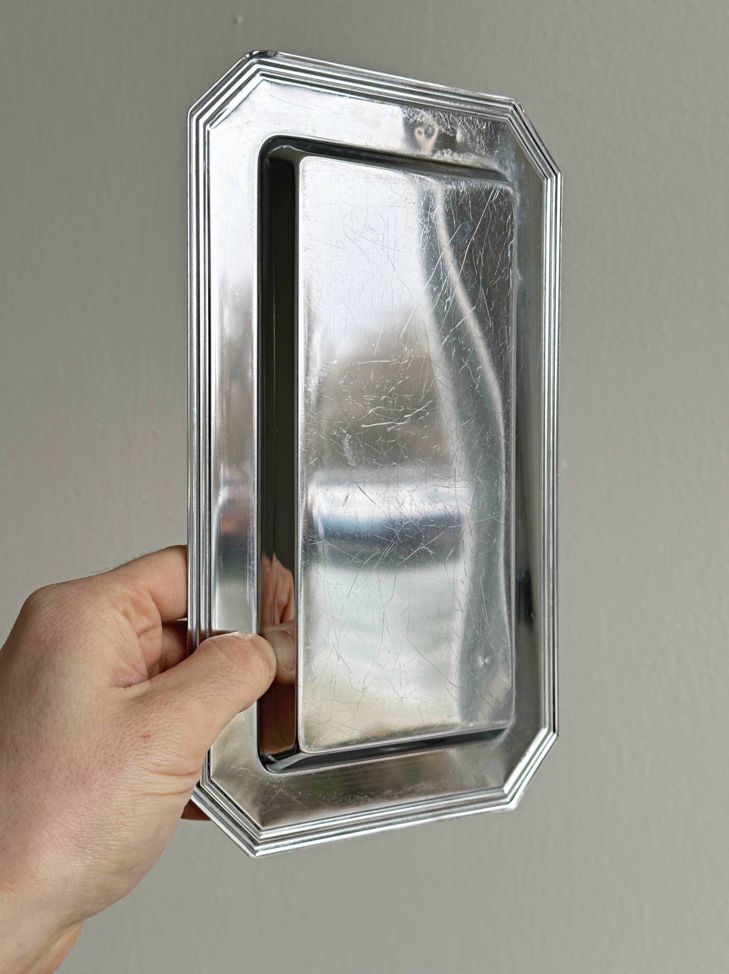 Small rectangular tray made of lightweight metal.