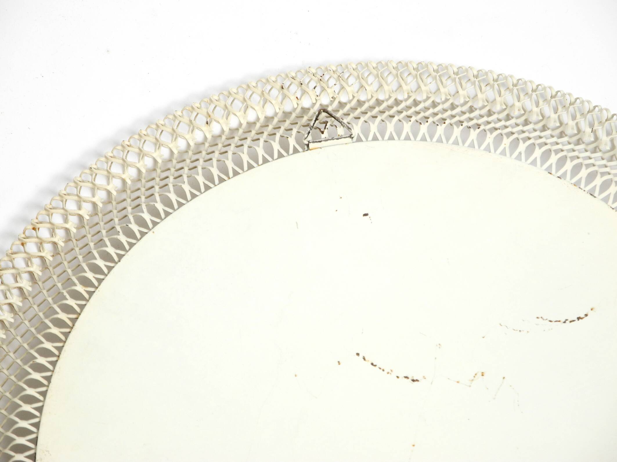 Mid Century Modern round wall mirror with a white expanded metal frame