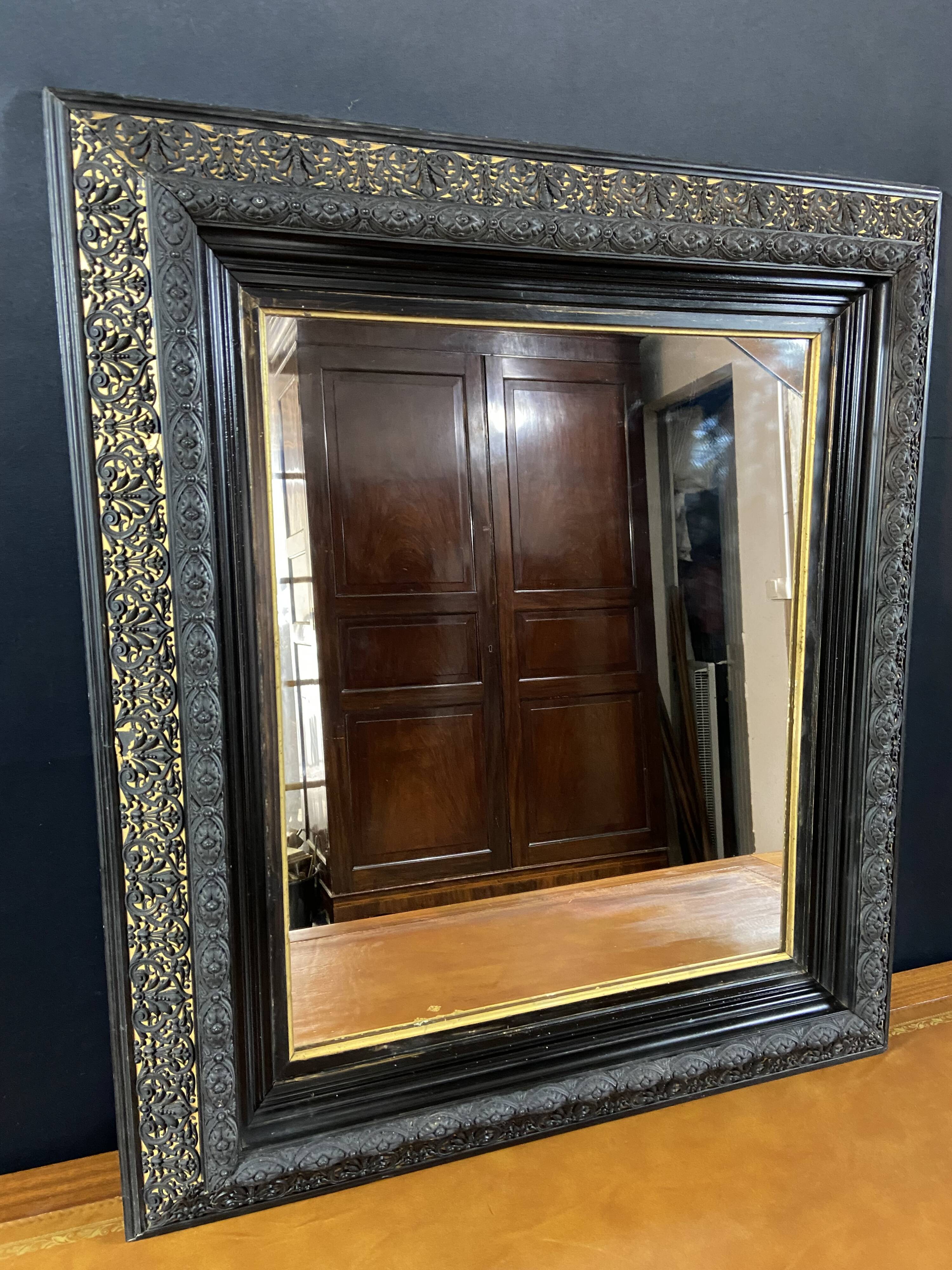 19th-century mirror Napoleon III in blackened wood on a gold background.