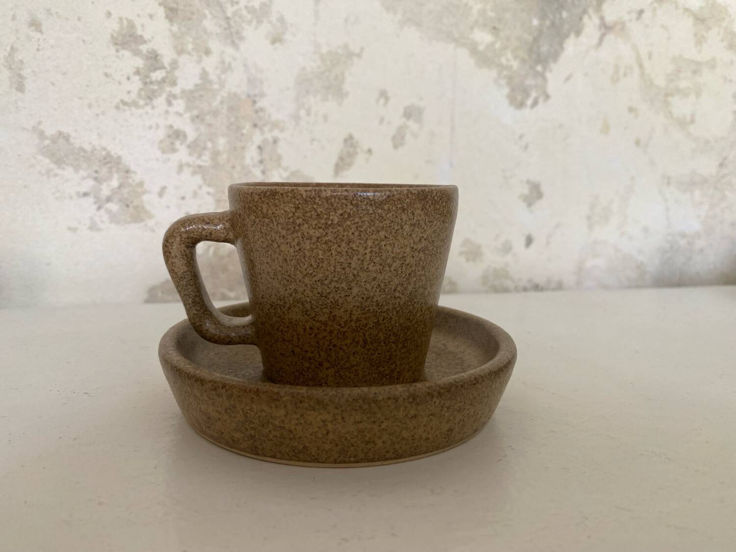 Set of stoneware coffee cups with saucers