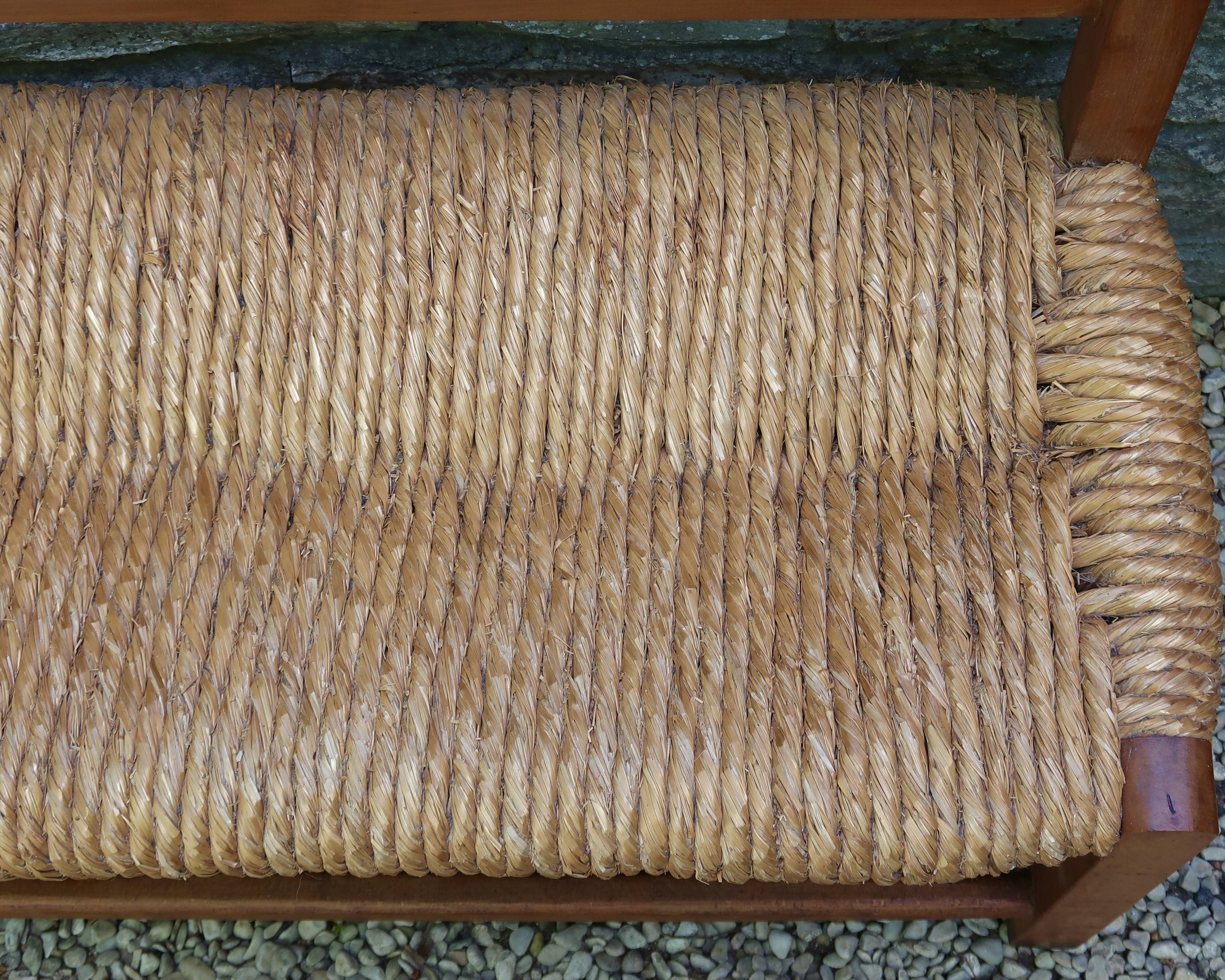 Wooden-backed bench with straw seat, 1970s.