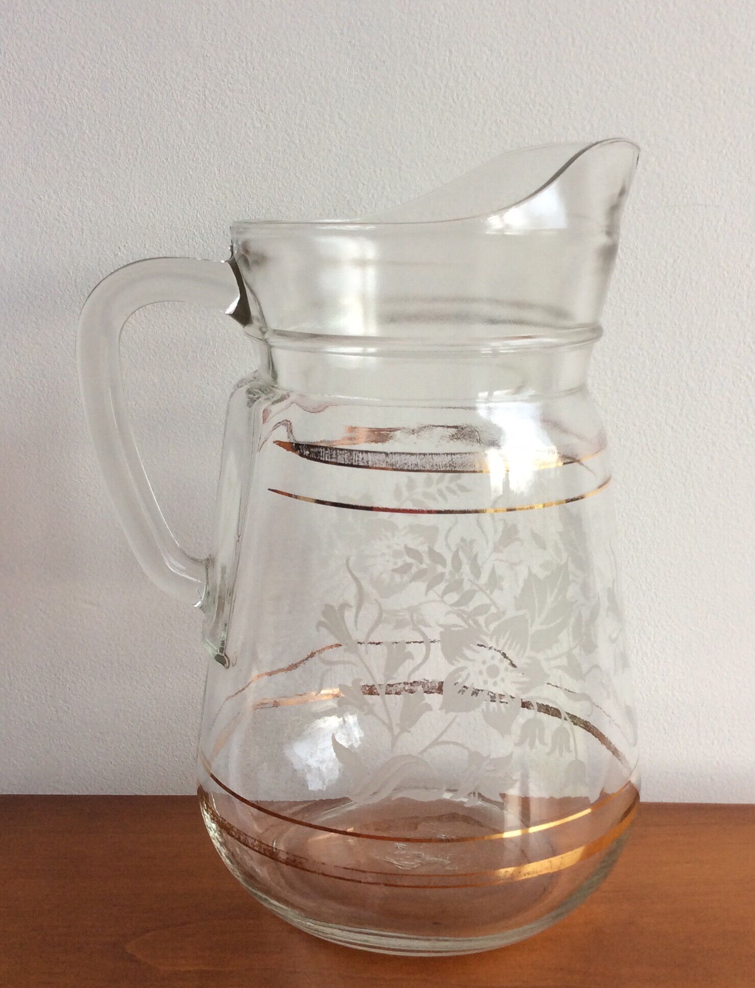 Old glass water pitcher with white flowers in relief with gold edging