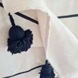 Handwoven throw with black stripes and pom-poms