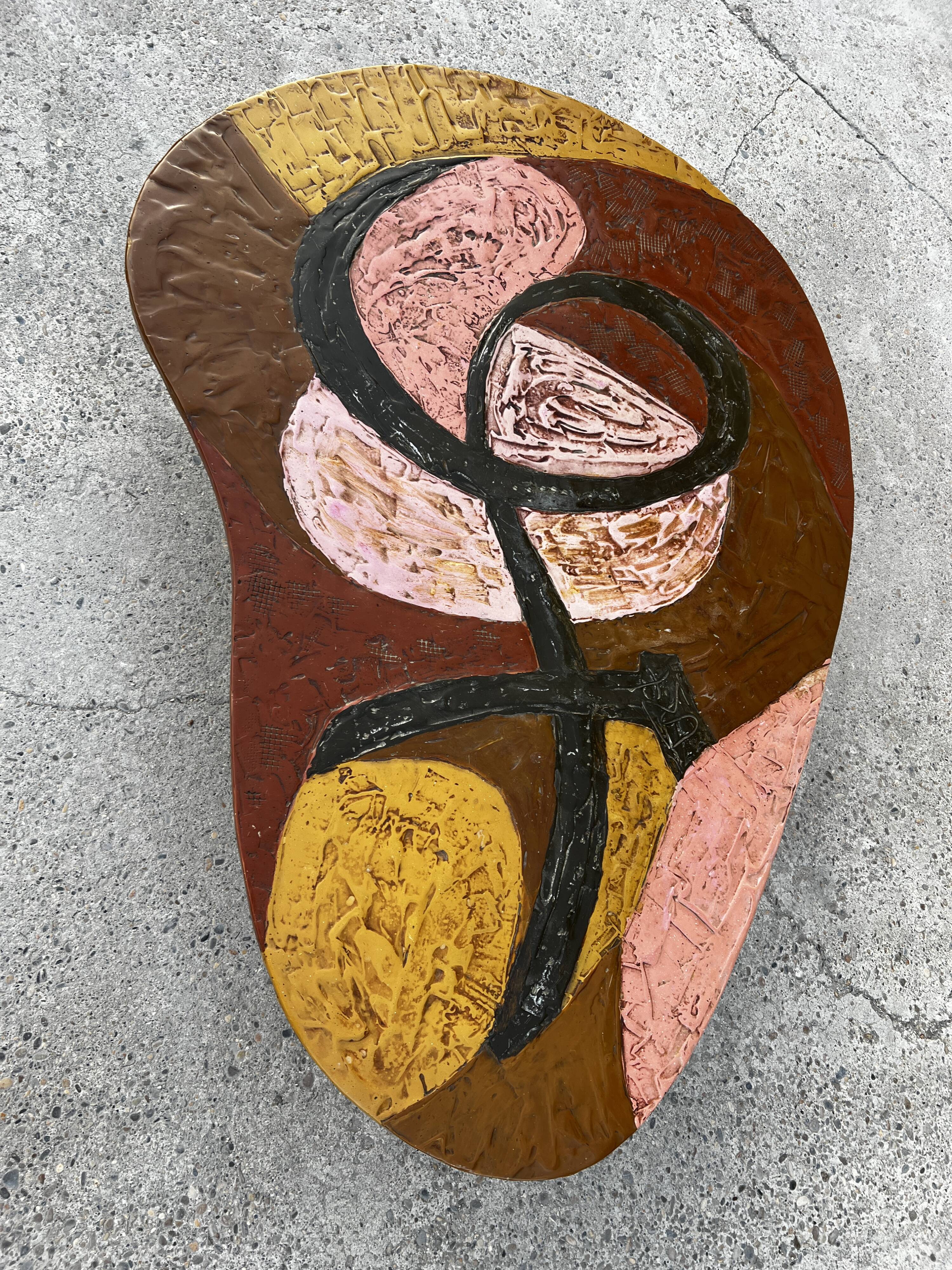 Table basse en résine scarifiée, pieds gainés de cuir marron signé 1960