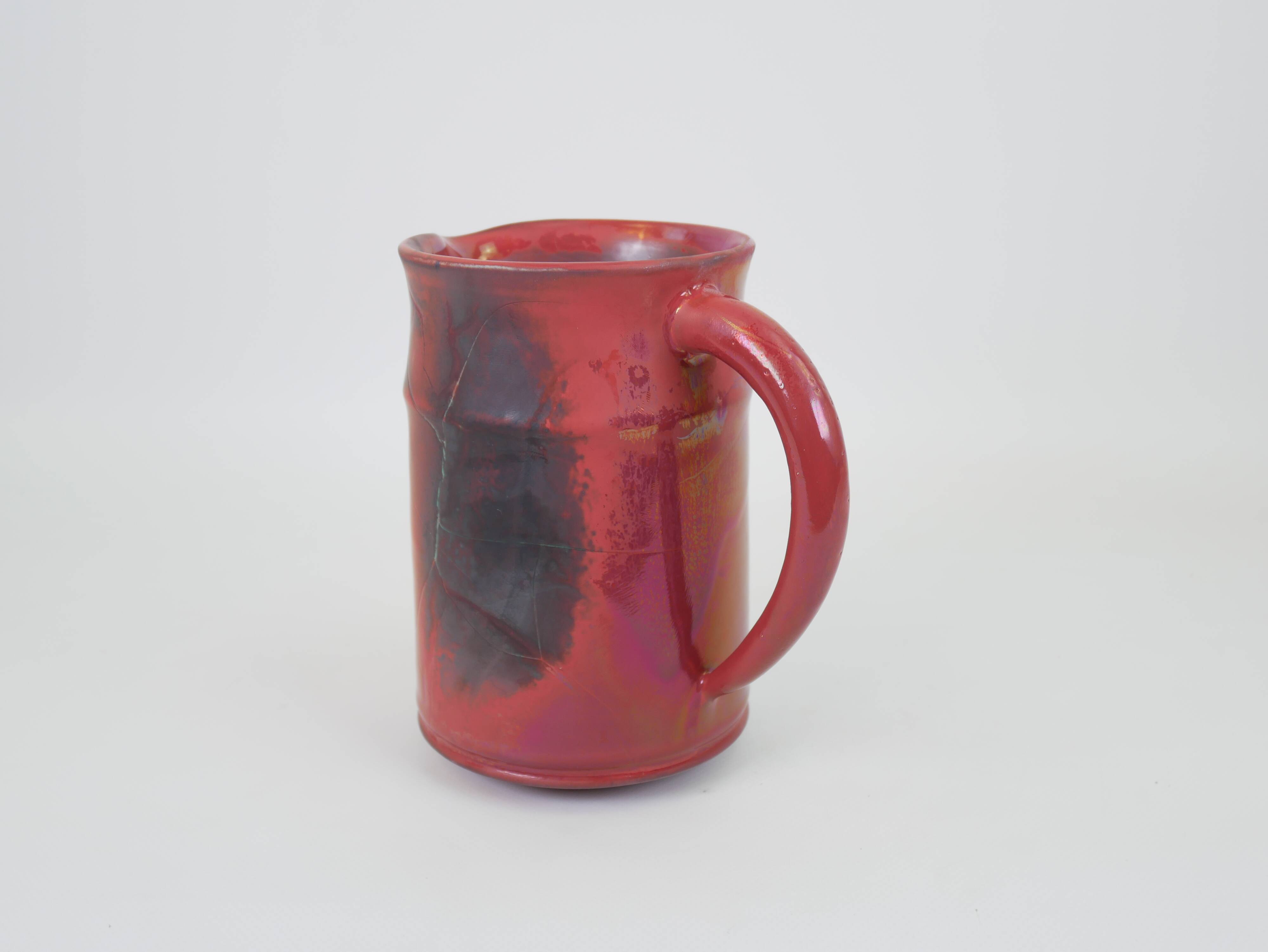 Red glazed ceramic jug with relief