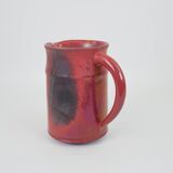 Red glazed ceramic jug with relief