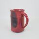 Red glazed ceramic jug with relief