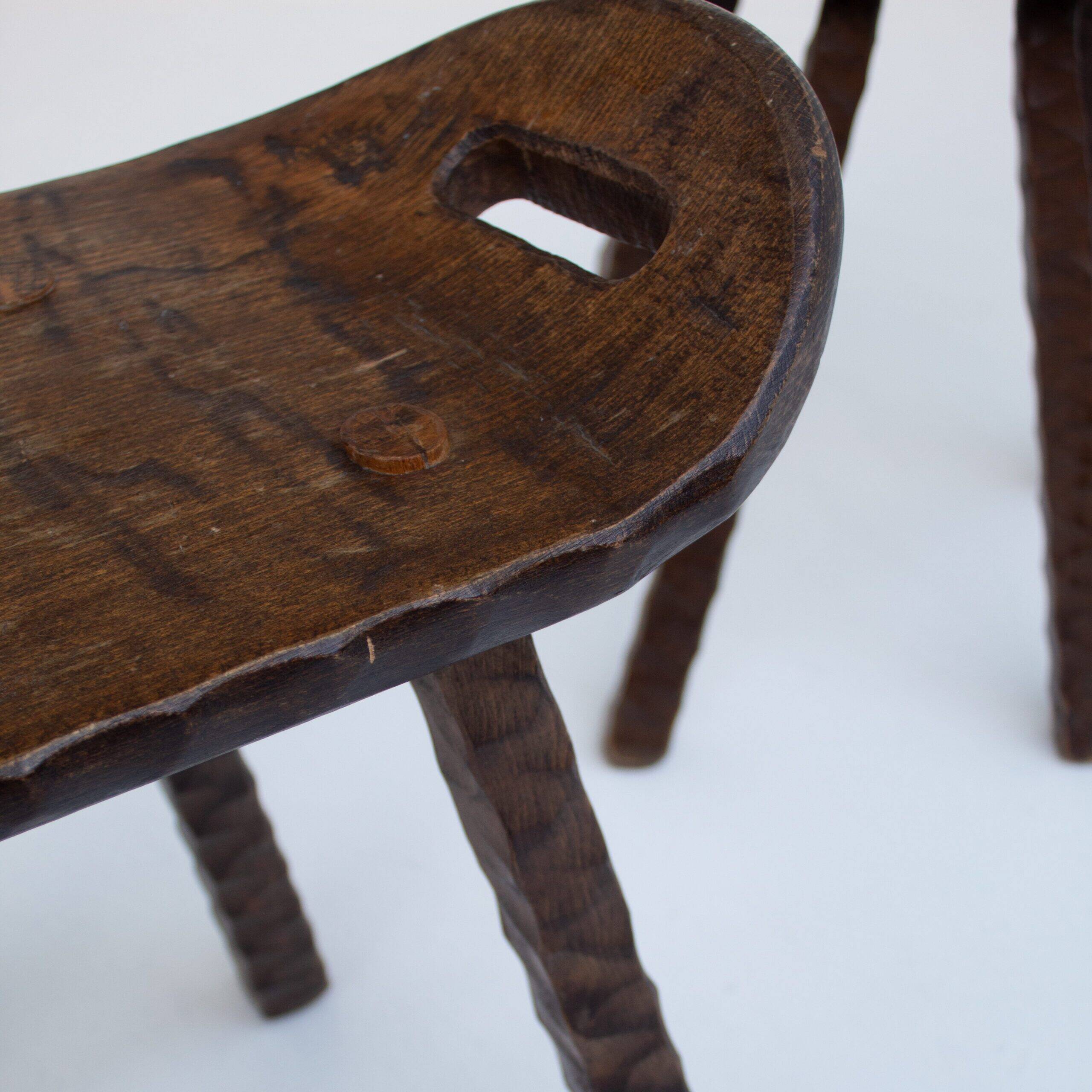 Ensemble de deux tabourets en bois sculptés à la main avec poignées.