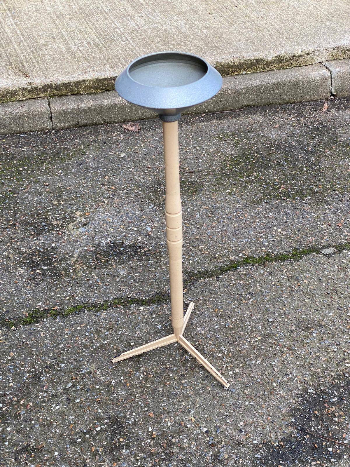Vintage ashtray on a beige and grey metal stand.