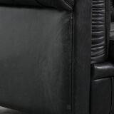 Comfortable black chesterfield armchair made of cowhide leather