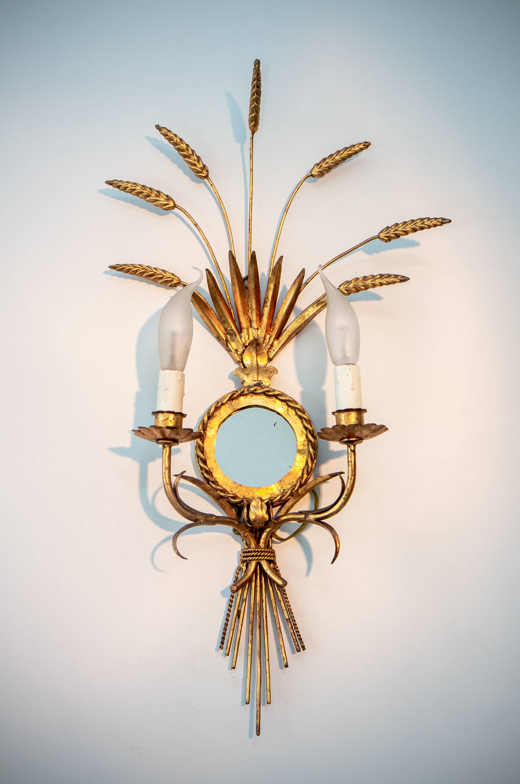 A pair of 1950s wall sconces in gold leaf metal.