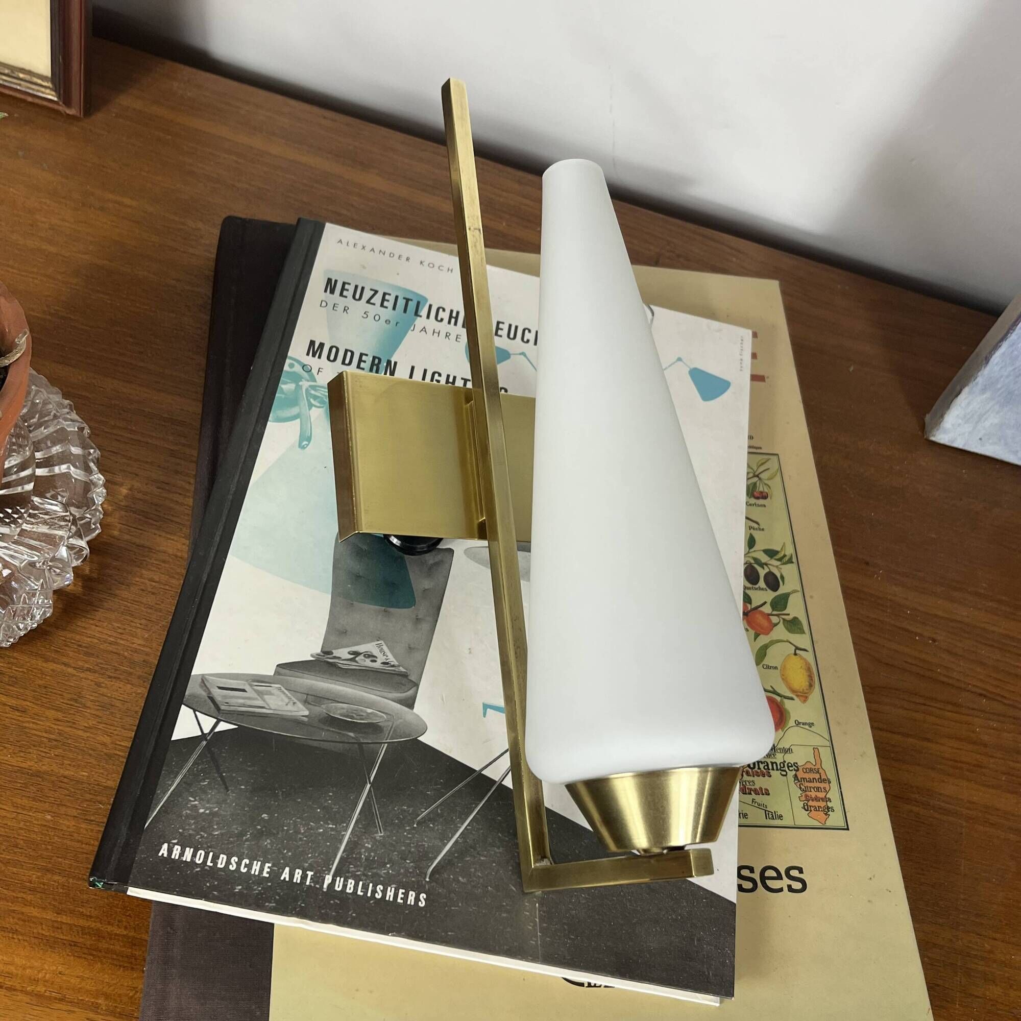 Vintage brass wall light with a white glass spindle shade from the 1950s-1960s.