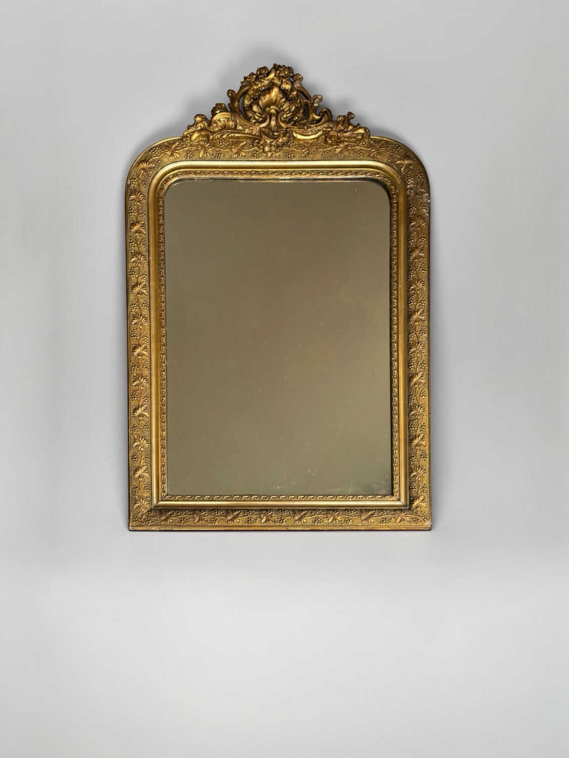 Golden mirror with a pediment from the early 20th century.