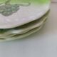 4 hand-decorated earthenware plates with vegetable and green leaf designs.