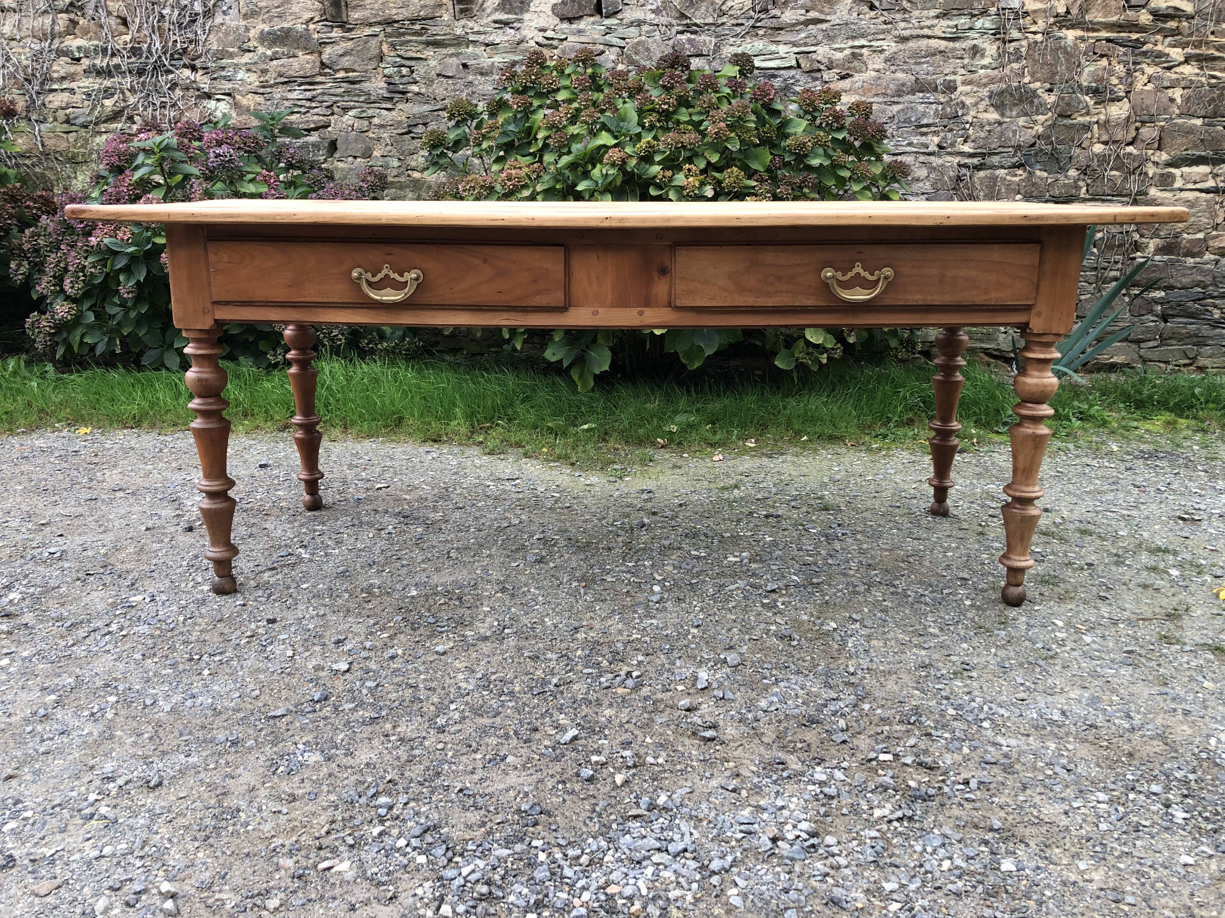 Antique Louis Philippe style farm table in solid cherry wood with 2 drawers and turned base.