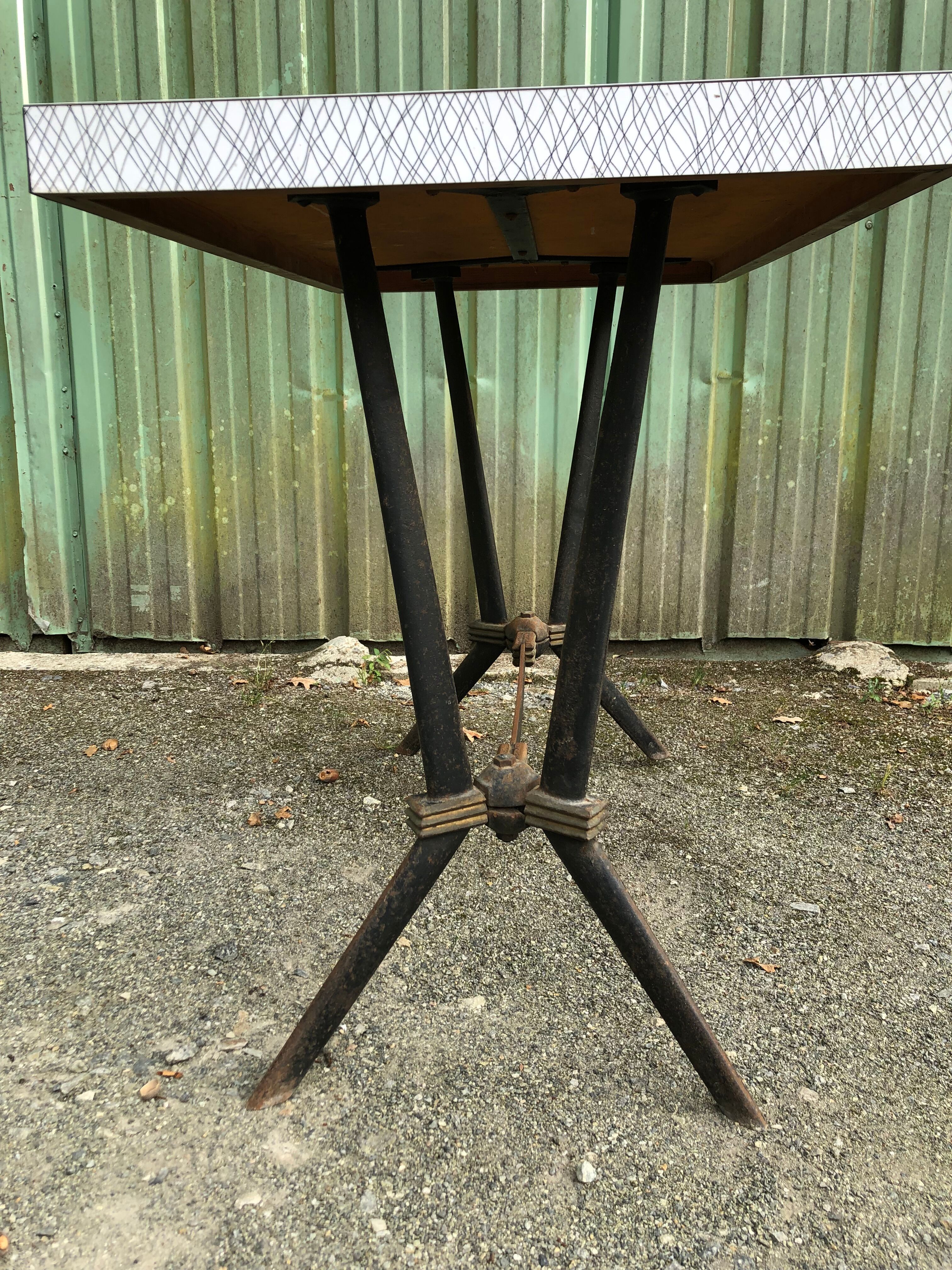 Vintage bistro table with an Art Deco style cast iron base and Formica top.